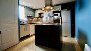 A modern kitchen with a central island, built-in oven, microwave, and stainless steel appliances. - Unit 1291248 - SWEET HOME OF THE VINES - (Rully)