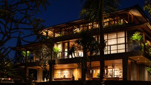 Un bâtiment moderne à deux étages, doté d’une façade en bois, de grandes fenêtres et de plantes d’intérieur.