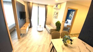 Uma sala de estar moderna com uma mesa de mármore, um sofá, uma televisão e uma área de jantar com cadeiras.
