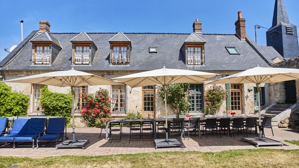 A building with a brick facade, multiple windows, and a large dining area with outdoor seating. - Le Presbytère, The Presbytery of Fourdrain (Fourdrain)