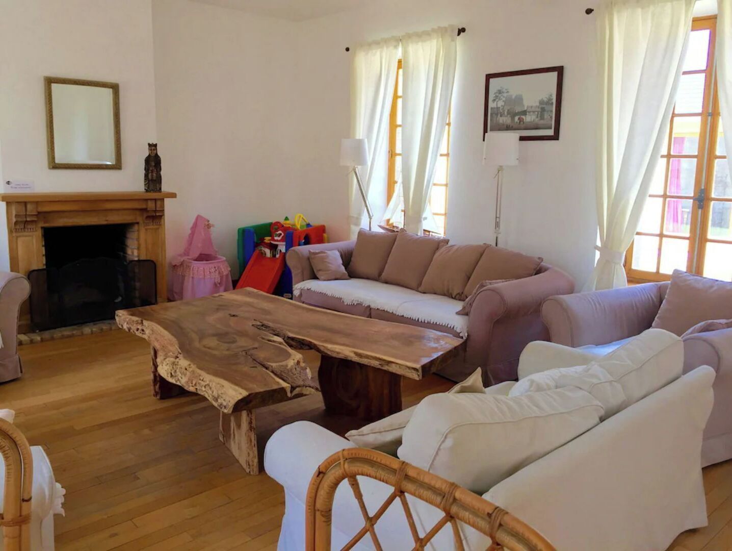 A cozy living room with a fireplace, a sofa set, and a wooden coffee table.