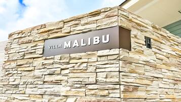 A stone wall with the sign "Villa Malibu" indicating a hotel or resort.