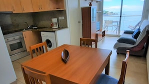 Cocina compacta con comedor y vista al mar.