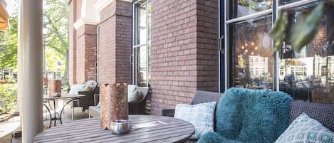An outdoor seating area with wicker furniture and a metal table.