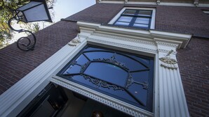 A building with a large, ornate window and a decorative light fixture. - Boutique Hotel Brasa Beemster (Middenbeemster)