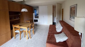 En kompakt bolig med spiseplads, tekøkken og sofa.