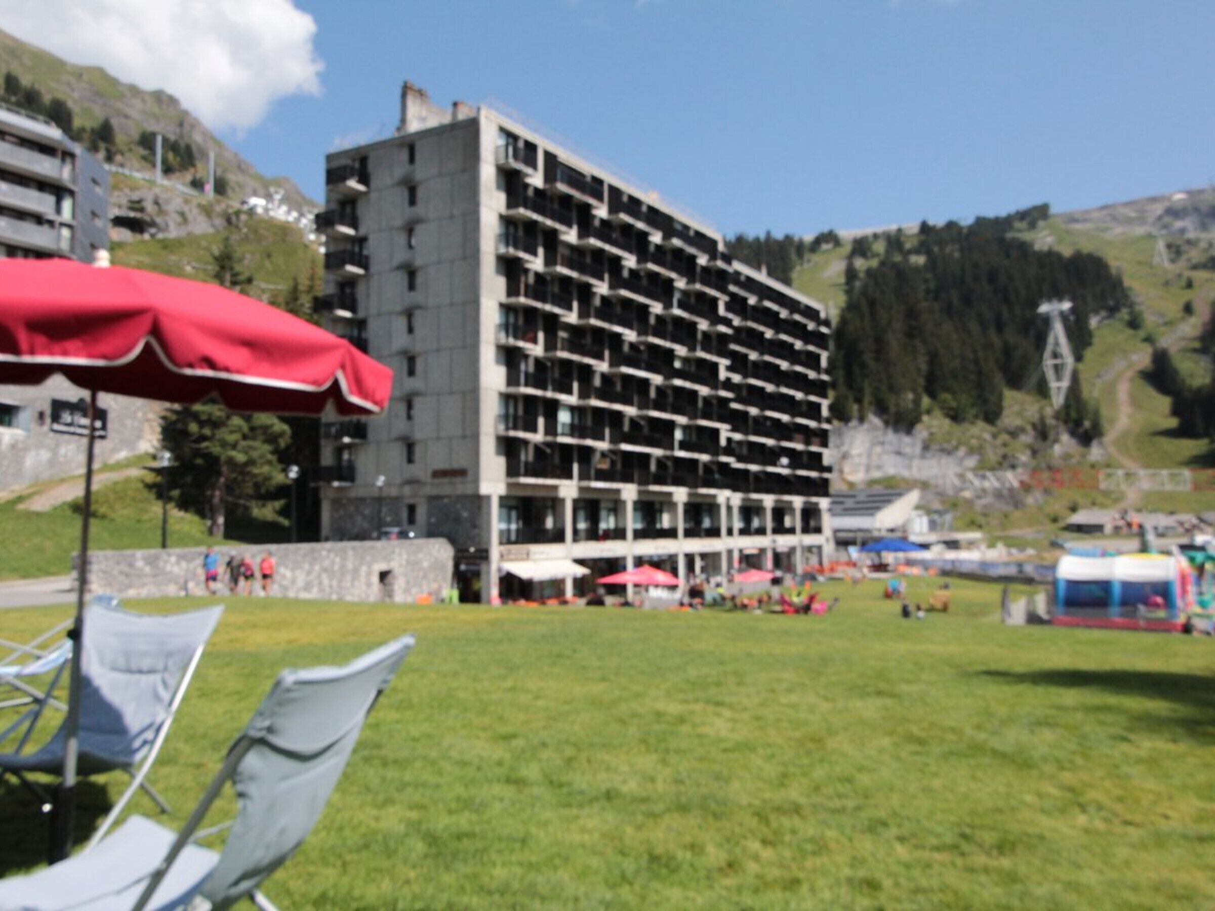 Un edificio de varios pisos con un diseño arquitectónico moderno, que cuenta con balcones y ventanas amplias.