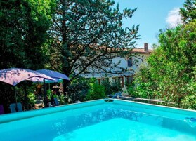 Una piscina al aire libre de temporada, sombrillas, tumbonas