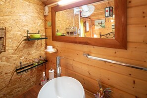 A wooden cabin bathroom with a large mirror, wooden walls, a white sink, and a towel rack. - Le Portel des Arnaud (Durfort-et-Saint-Martin-de-Sossenac)