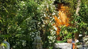 A garden pathway with potted plants and a statue.