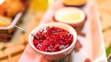 Un vassoio con una ciotola contenente cibo rosso, gelatinoso e un cucchiaio.