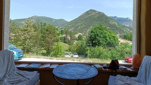 Una habitación con vista a montañas, una mesa con un mapa y una silla.