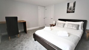 A bedroom with a bed, a desk, and a chair. - Friary House Serviced Apartments by Roomsbooked - 24Hr Reception (Gloucester)