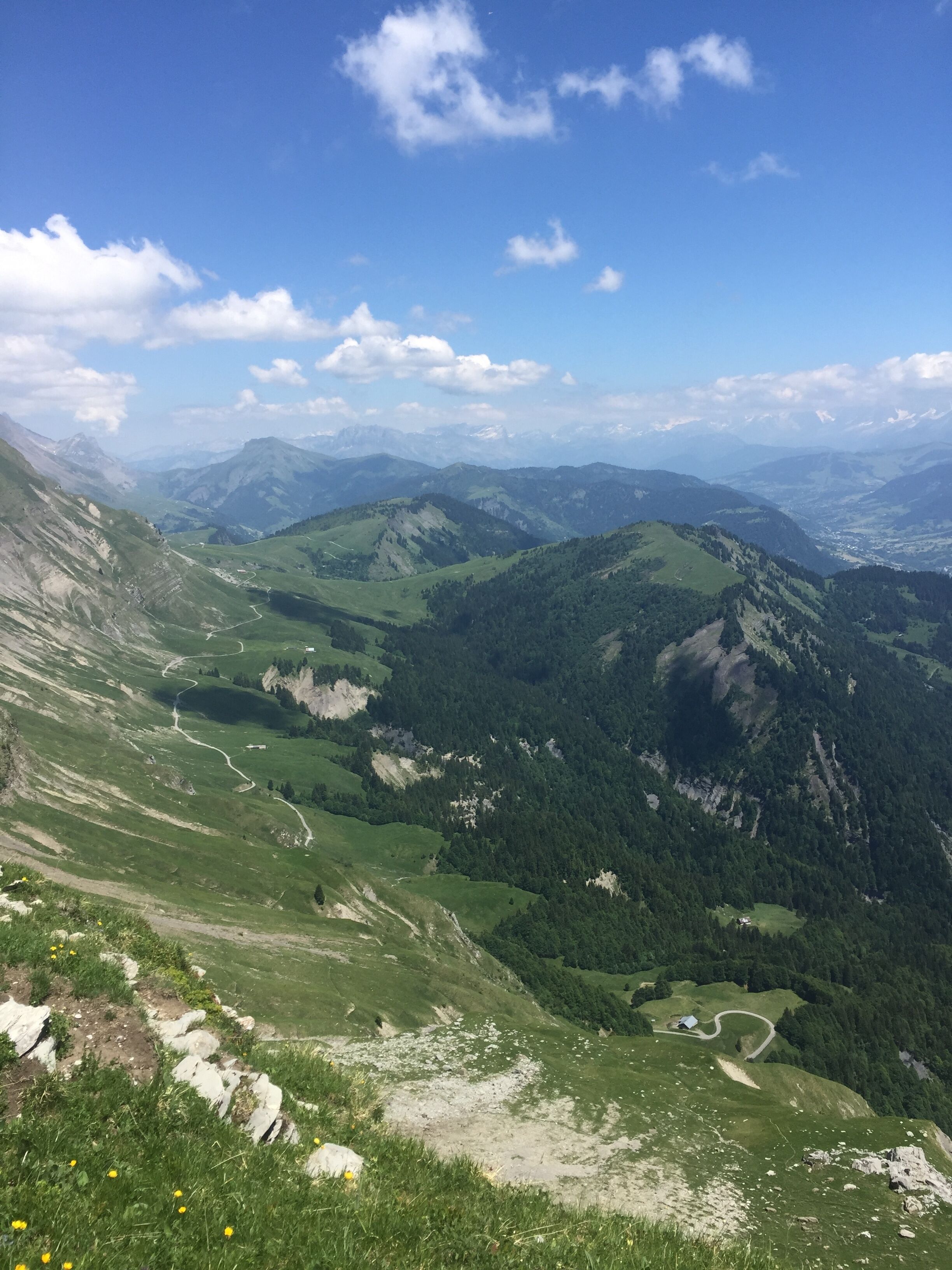 Eine gebirgige Landschaft mit einer kurvenreichen Straße und einem kleinen Gebäude.
