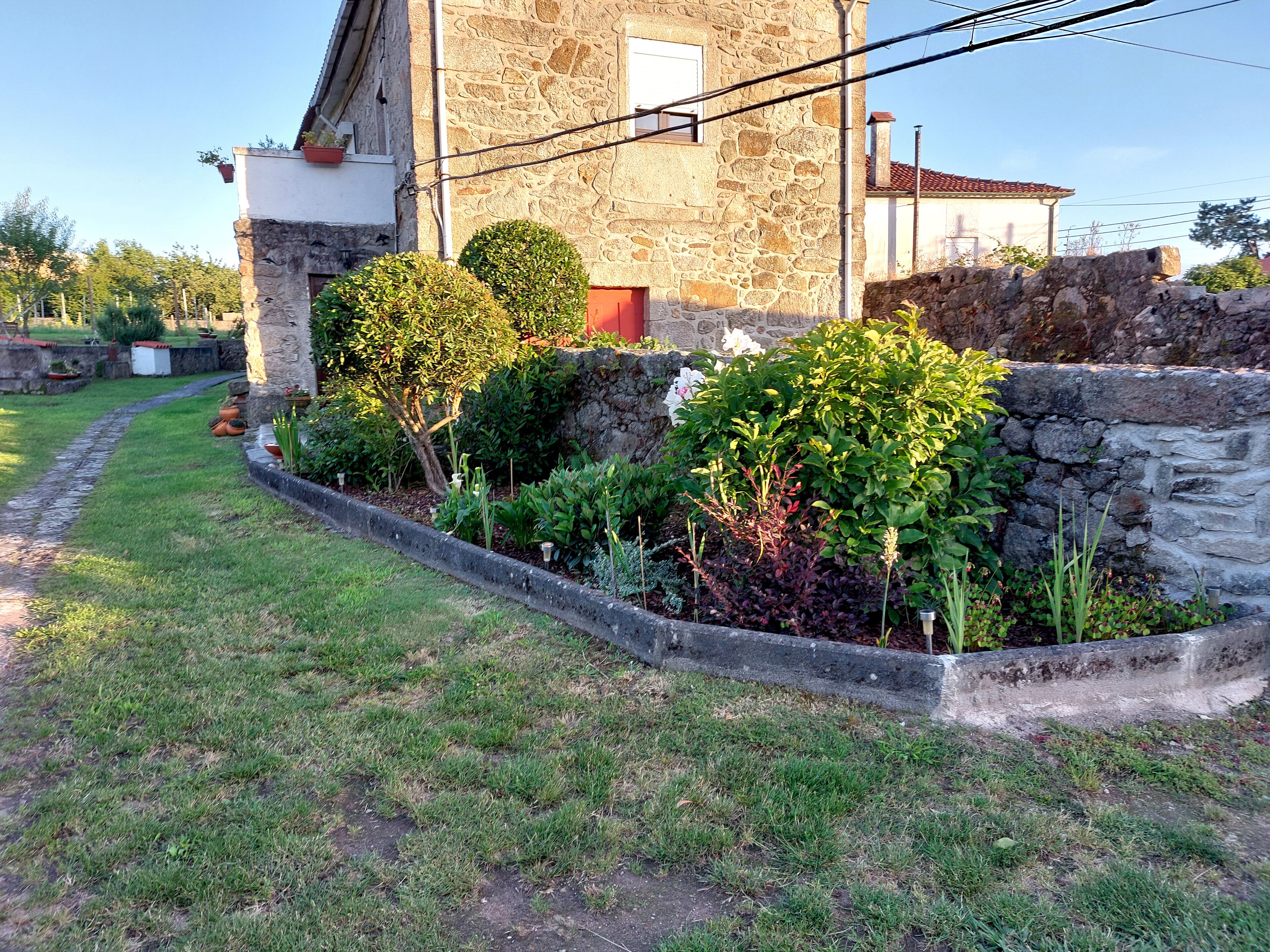 A stone building with a garden in front.