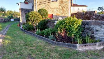 A stone building with a garden in front.