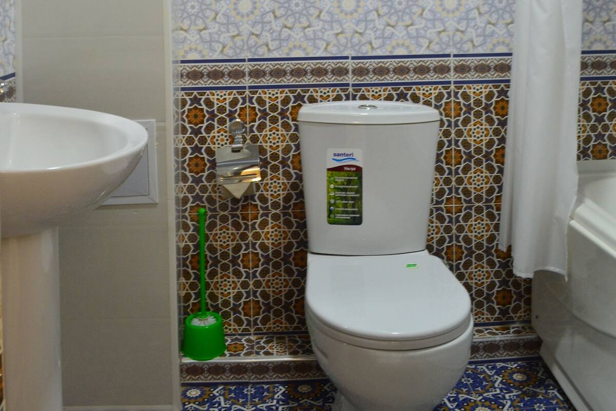 A bathroom with a toilet, sink, and shower curtain.