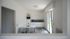 Eine moderne Küche mit weißen Schränken, einer herzförmigen Dekoration und einem Essbereich mit Tisch und Stühlen.