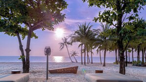 A beach with a sign reading "SEA SHACK," lounge chairs, and palm trees. - MARINA SEASIDE BOUTIQUE HOTEL (Phu Quoc)