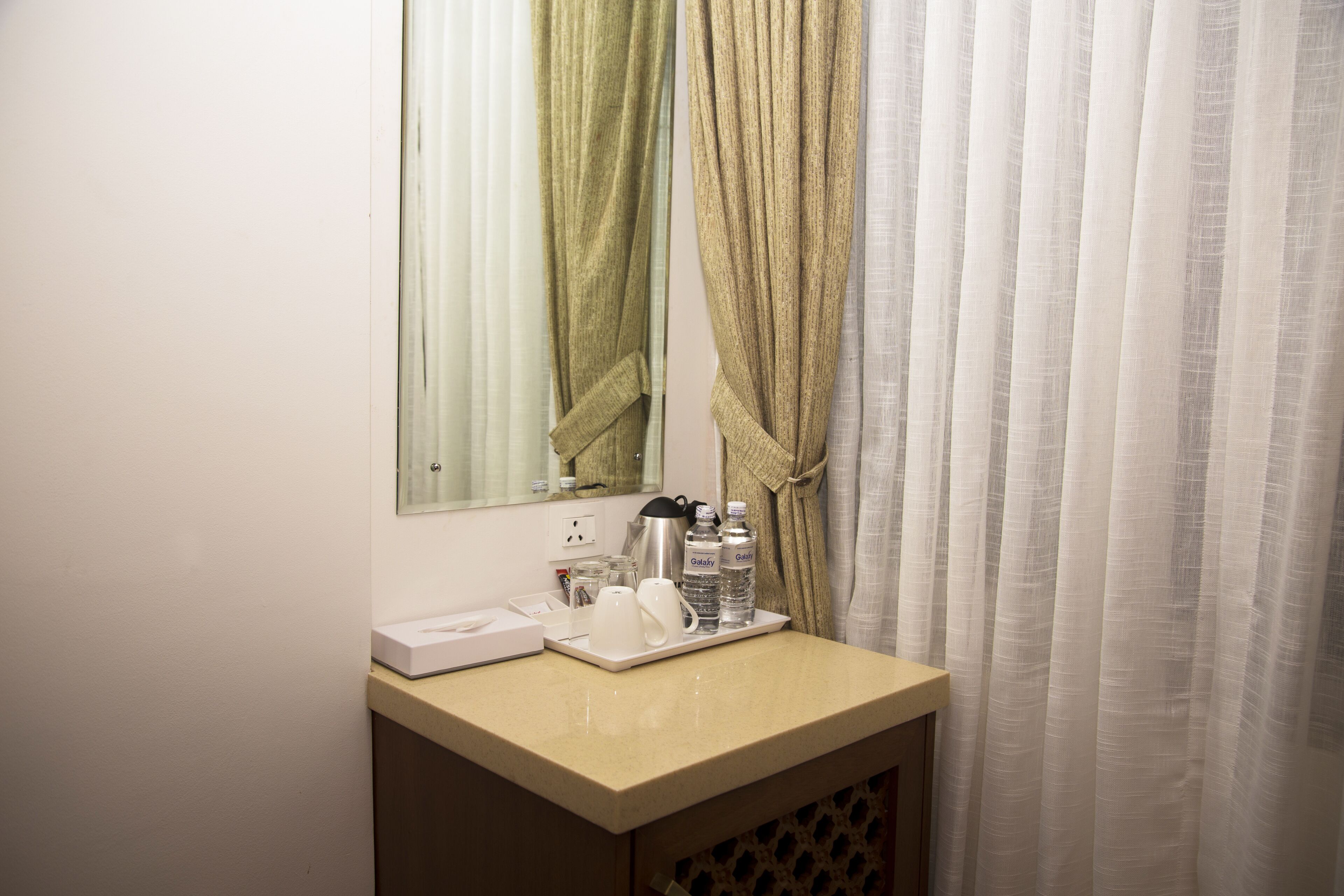Une salle de bain d’hôtel avec un lavabo, un miroir et des articles de toilette posés sur le comptoir.