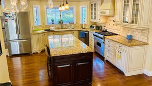 A spacious kitchen with a large island, stainless steel appliances, and a view of the outdoors. - Tranquil & clean 5-acre getaway (Grass Valley)