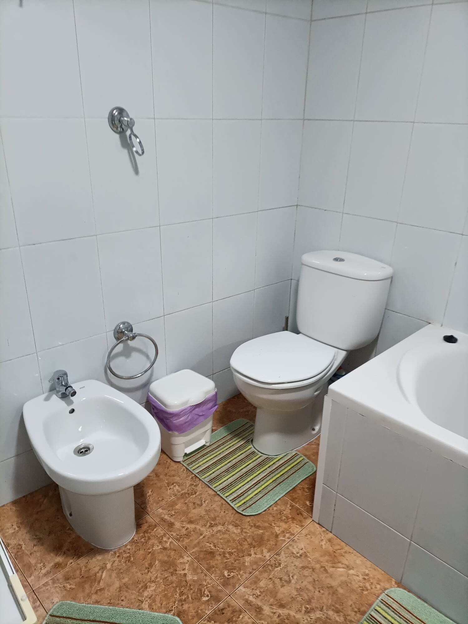 Un baño con bidé, inodoro y lavamanos.