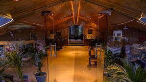 An interior with a high ceiling, wooden beams, and a central staircase leading to a second floor. - Montrose 11 Boutique (Kasauli)
