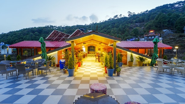 A hotel with a checkered floor, outdoor seating area, and potted plants. - Montrose 11 Boutique (Kasauli)