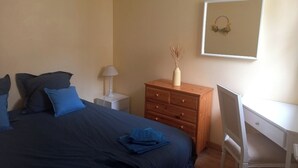 A bedroom with a bed, a desk, a dresser, and a wall-mounted picture. - House in historic center of Caen! (Caen)