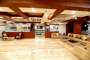 A spacious lobby with a reception desk, seating area, and a patterned floor. - Udman Hotel Haridwar (Haridwar)