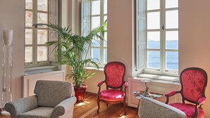 Una habitación con dos ventanas, una planta en maceta y dos sillas.