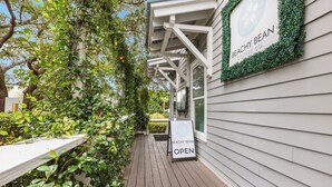 A wooden deck with a sign indicating 'BEACHY BEAN COFFEE CO. OPEN'. - Watersound - Golf Cart - Pet Friendly - Bikes (Watersound)