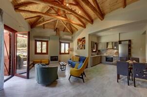 Un área de sala y comedor de concepto abierto con un techo alto de madera, un sofá, una silla y una mesa de comedor.