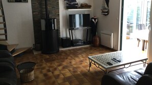 A living room with a fireplace, a TV, a table, and a sofa.