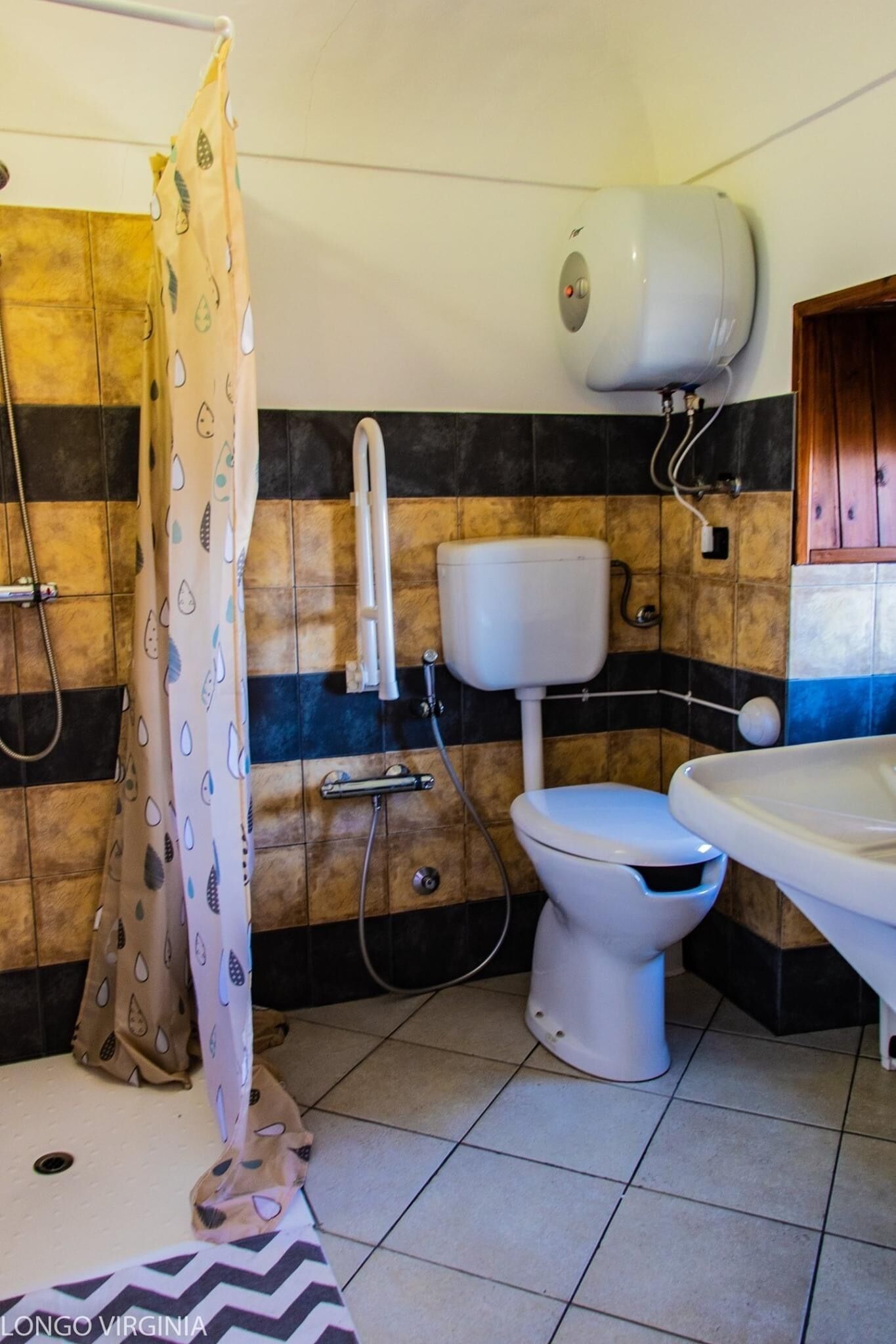 Ein Badezimmer mit Dusche, Toilette und Waschbecken.