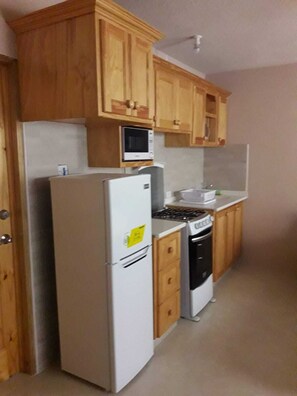 Kylskåp, mikrovågsugn, spishäll och grytor/köksredskap