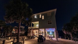 Un bâtiment à deux étages doté d’un espace extérieur couvert et devant lequel est garée une voiturette de golf.
