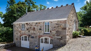 A stone building with two white doors and a small porch area.