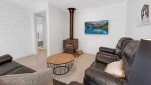 Una sala de estar con chimenea, un sofá, una mesa de centro y un cuadro en la pared.