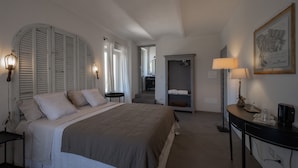 A bedroom with a large bed, bedside lamps, a wardrobe, a desk with a lamp, and a framed picture on the wall. - THERESA SULLA COLLINA (Passerano Marmorito)