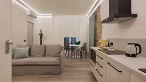 Una cocina moderna con estufa integrada, cafetera y comedor con mesa y sillas.
