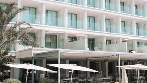 A multi-story hotel with balconies, outdoor seating, and palm trees. - Diamant Hotel y Aparthotel (Capdepera)