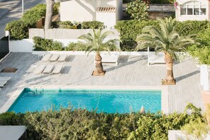 A rooftop pool with lounge chairs and palm trees. - Diamant Hotel y Aparthotel (Capdepera)