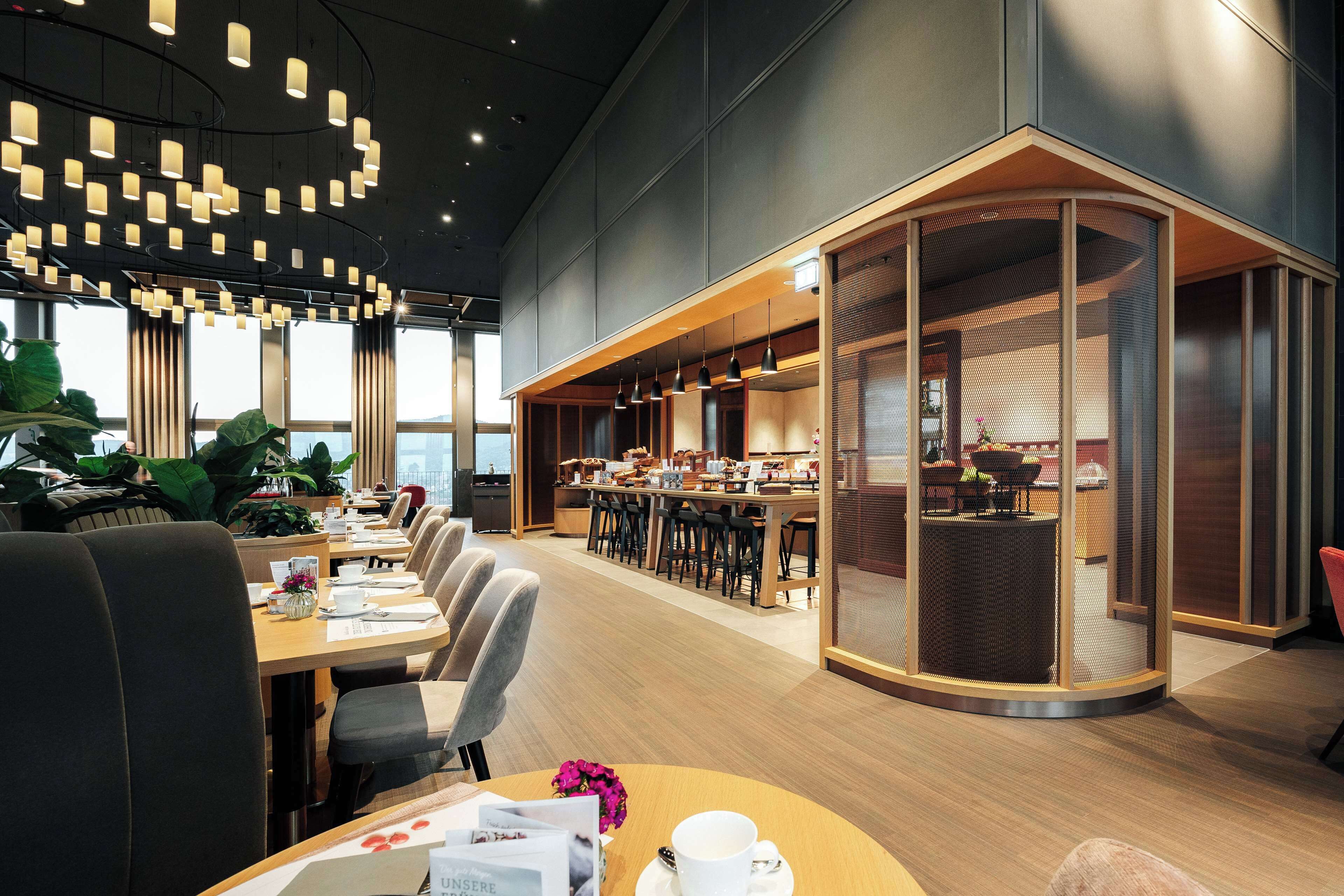 A modern office space with a long table, chairs, and a seating area with a view.