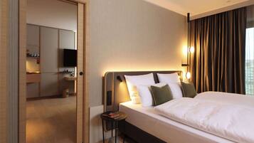 Una habitación de hotel con cama, mesita de noche y televisión.