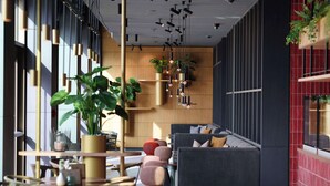 A modern interior with a sofa, tables, and hanging plants.