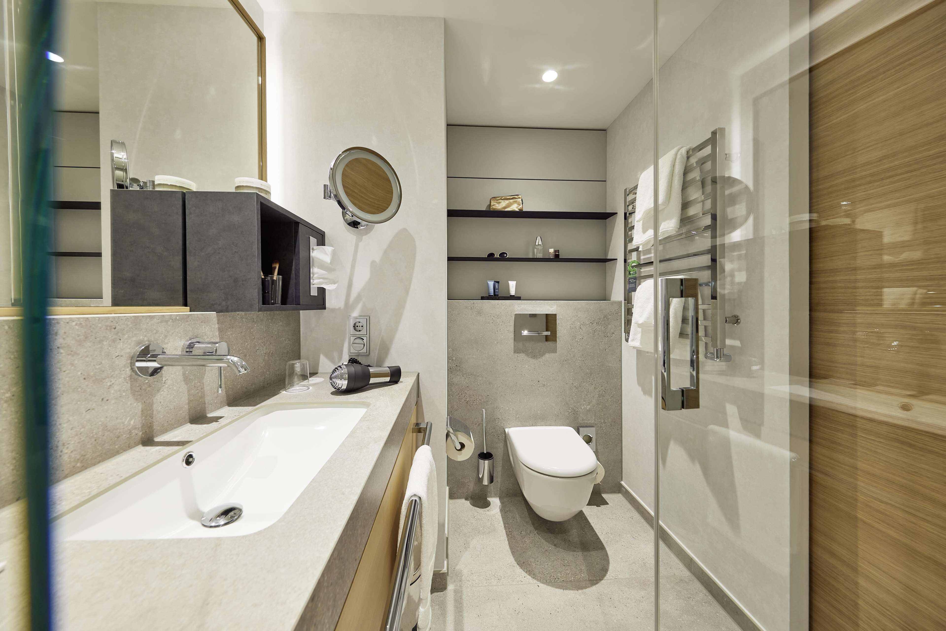 Un baño moderno con una bañera grande, un inodoro y una cabina de ducha de vidrio.