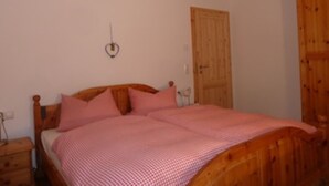 A bedroom with a wooden bed, a wooden wardrobe, and a small bedside table. - Feel-good apartment TANNE (Sankt Blasien)