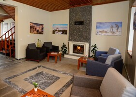 Una sala de estar con chimenea, sofás, una mesa de centro y una escalera.