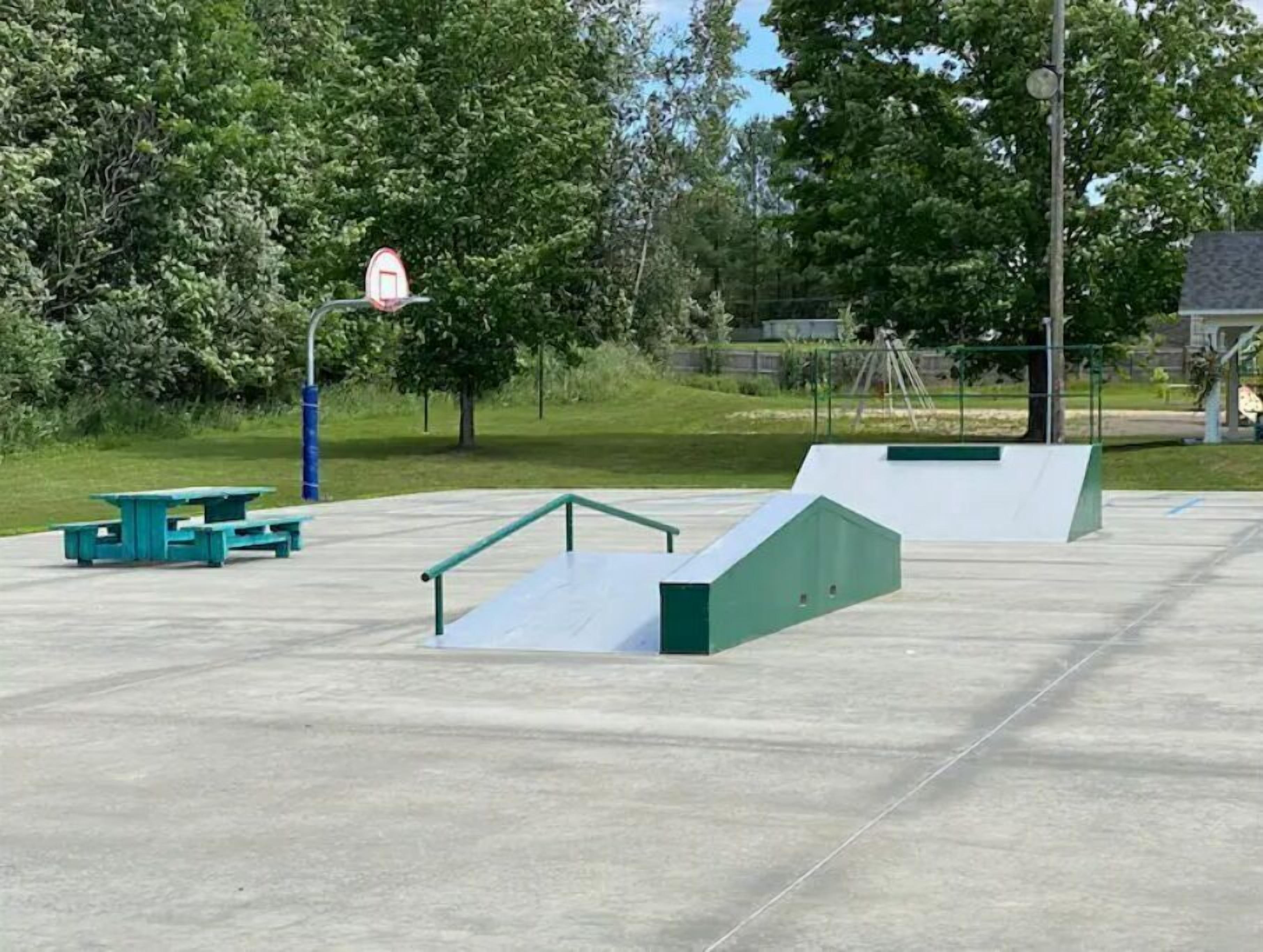 Un parco di skateboard con rampe e tavoli da picnic.